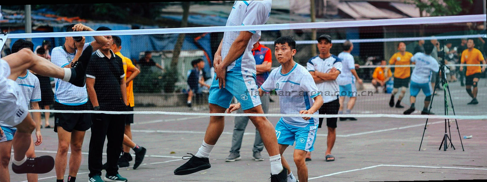 暗光下的赛事场馆看台剪影，青色调灯光铺满画面，画面中没有人脸